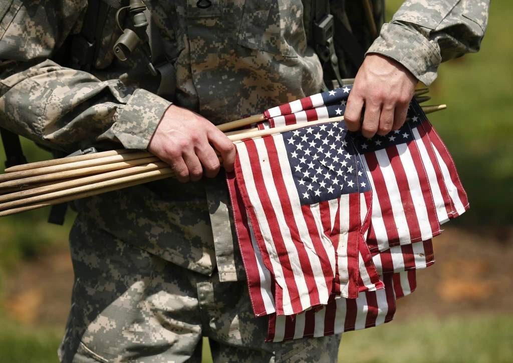 A member of the Third U.S. Infantry Regiment carries flags during a
