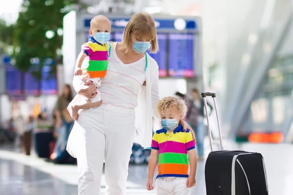 Family in airport in face mask. Virus outbreak.